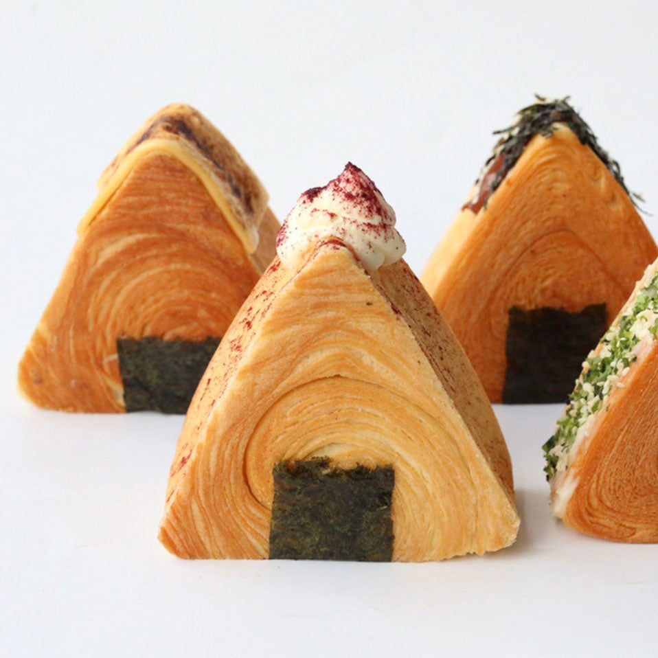 Three triangular pastries with different fillings on a white background