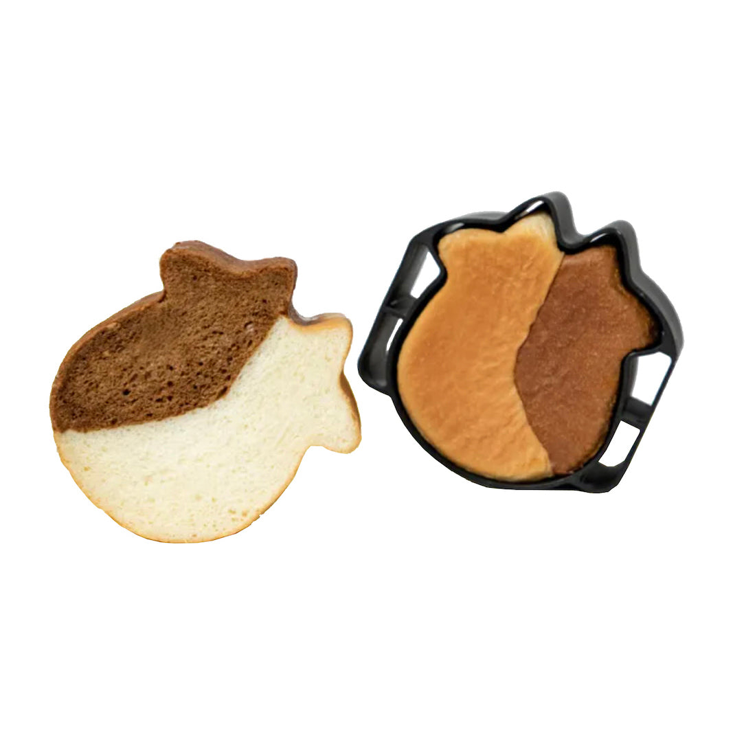 Two cow-shaped sandwich bread slices shown on a plain white background, one sliced open to reveal the interior crumb and one in a black tray showing the baked surface.