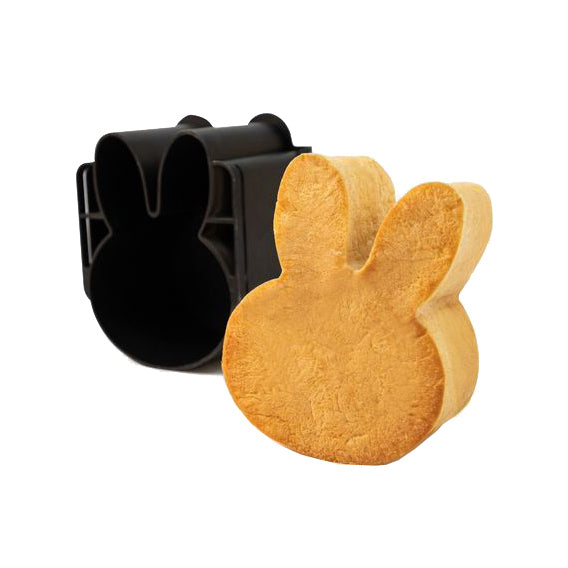 A black Sanneng bunny-shaped baking mold shown behind a baked golden-brown bunny-shaped cookie on a plain white background.