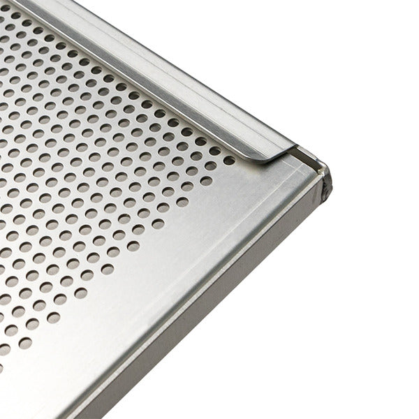 Close-up of a stainless steel perforated panel with a brushed metal frame and raised edge, shown on a white background.