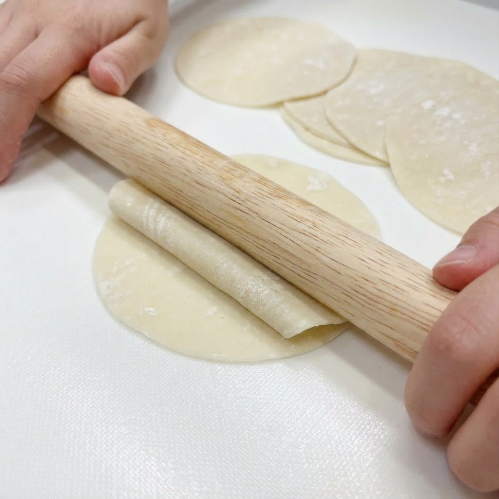 Person rolling out dumpling dough with a Sanneng small wooden rolling pin SN8030 on a white surface