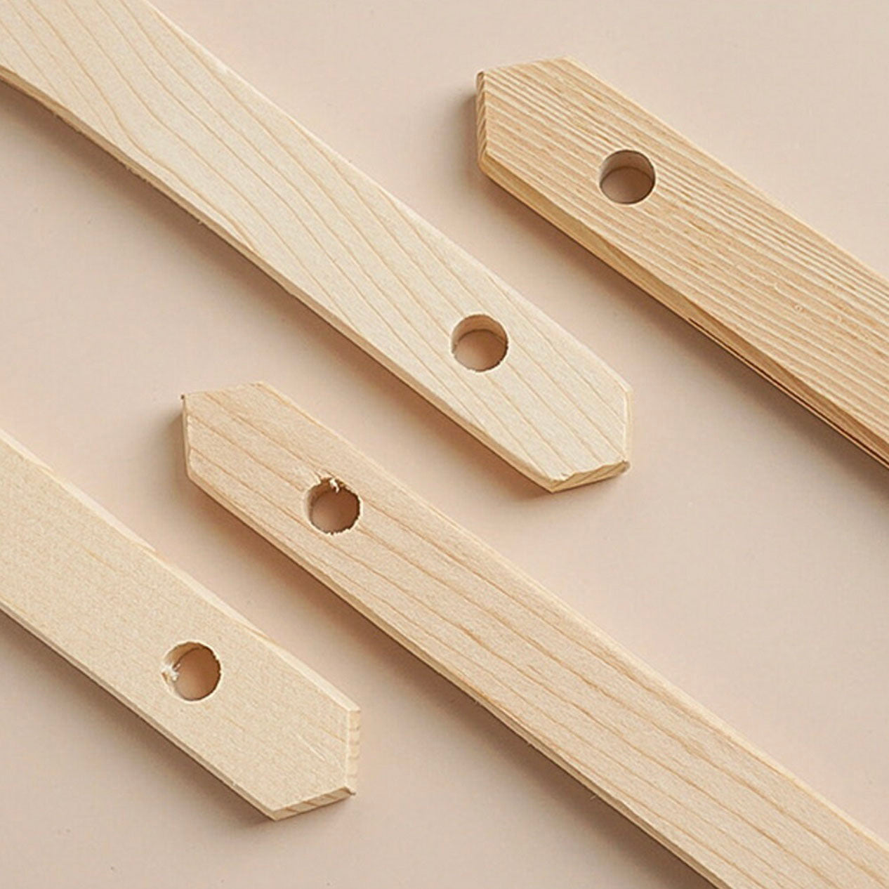 Sanneng wooden pastry brush handles with holes on a beige background
