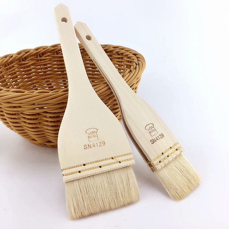 Two wooden basting Sanneng brushes with natural bristles on a white background