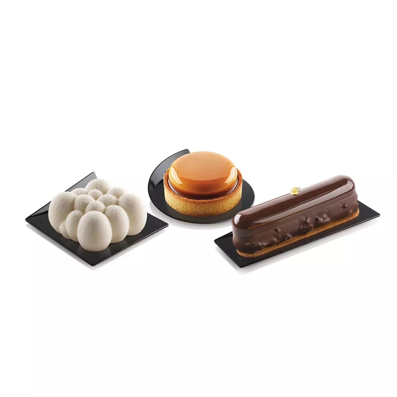 Three different desserts on black square plates against a white background