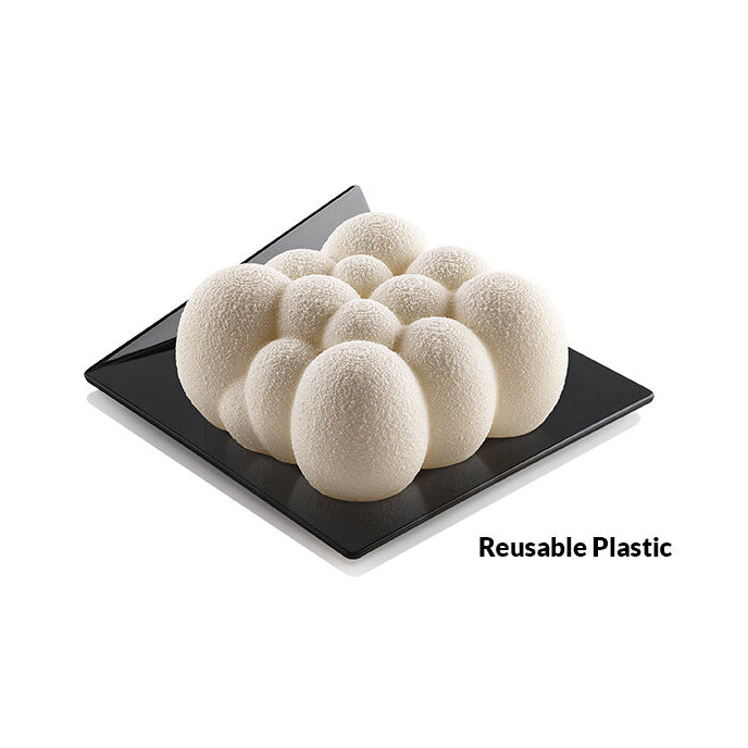 White spherical dessert on a black square plate with 'Reusable Plastic' text.