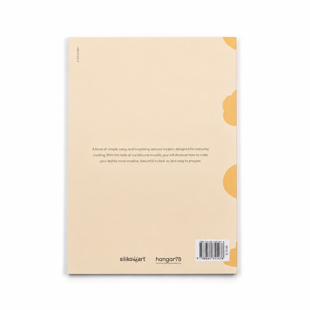 The back cover of Silikomart recipe book, shown flat against a white background. The cover is a warm cream-beige color with a small yellow abstract shape on the right side and black text near the bottom, including the silikomart brand logo and a barcode.