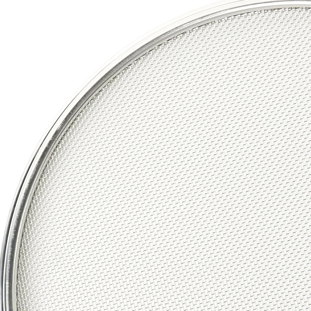 Close-up of a round metal mesh filter on a white background