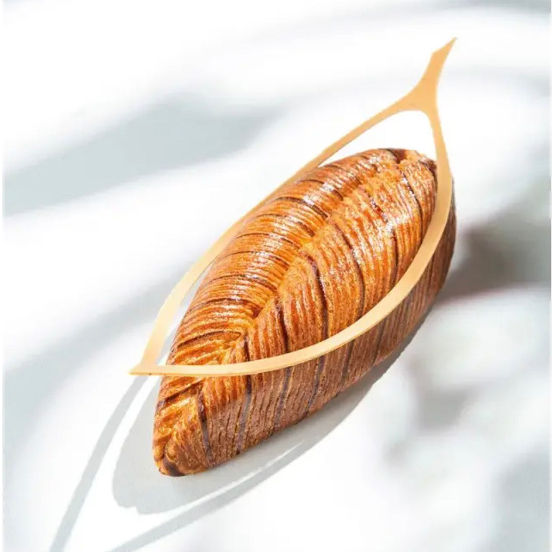 Loaf of bread with a decorative wooden board on a white background