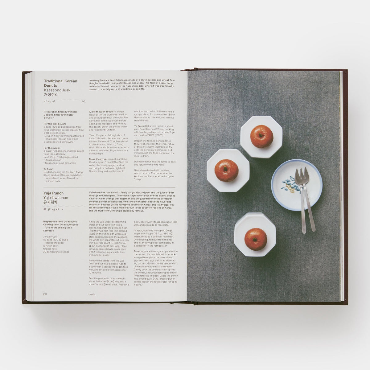 Open book with a page showing text and another with an image of apples on plates.