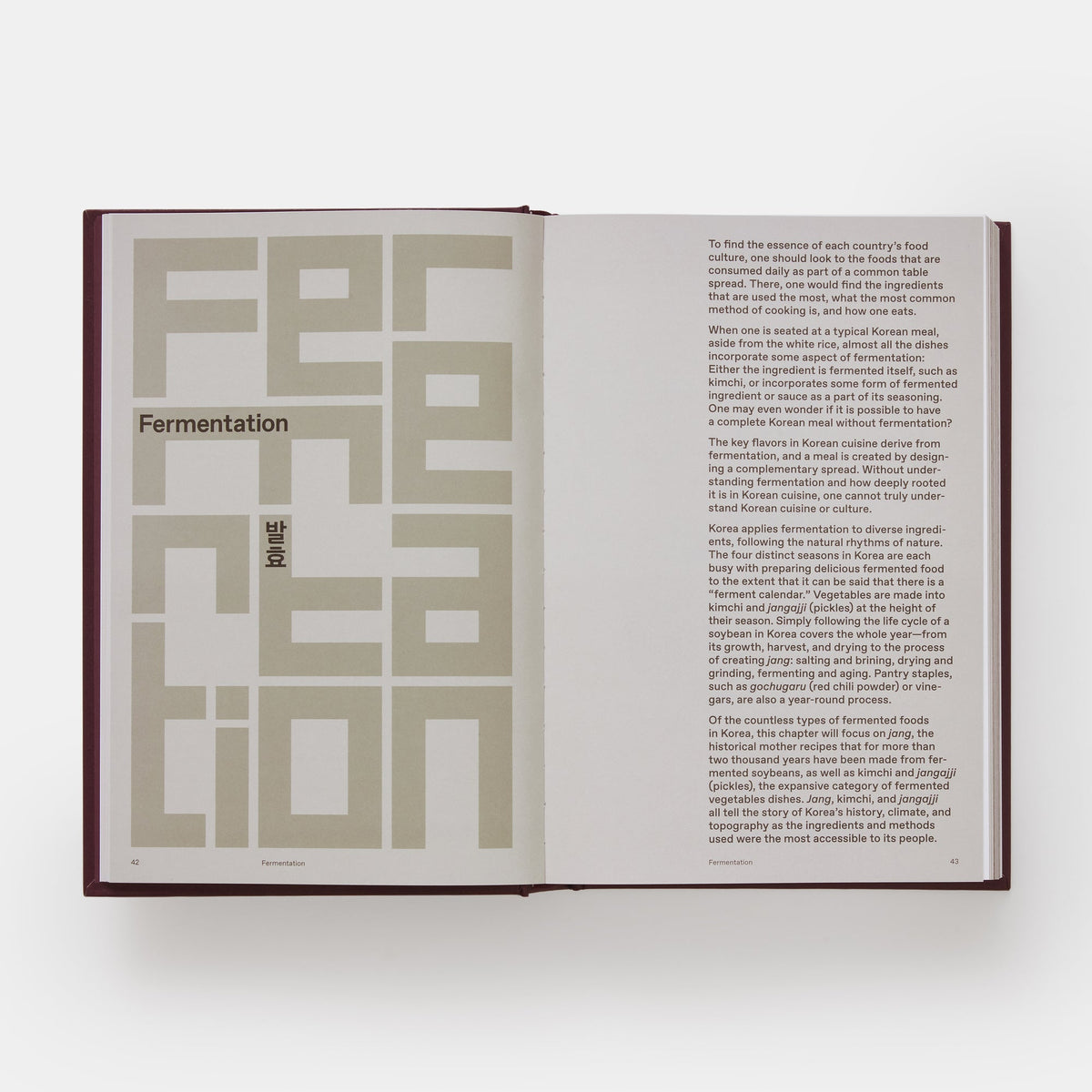 Open book with text and geometric design on a white background