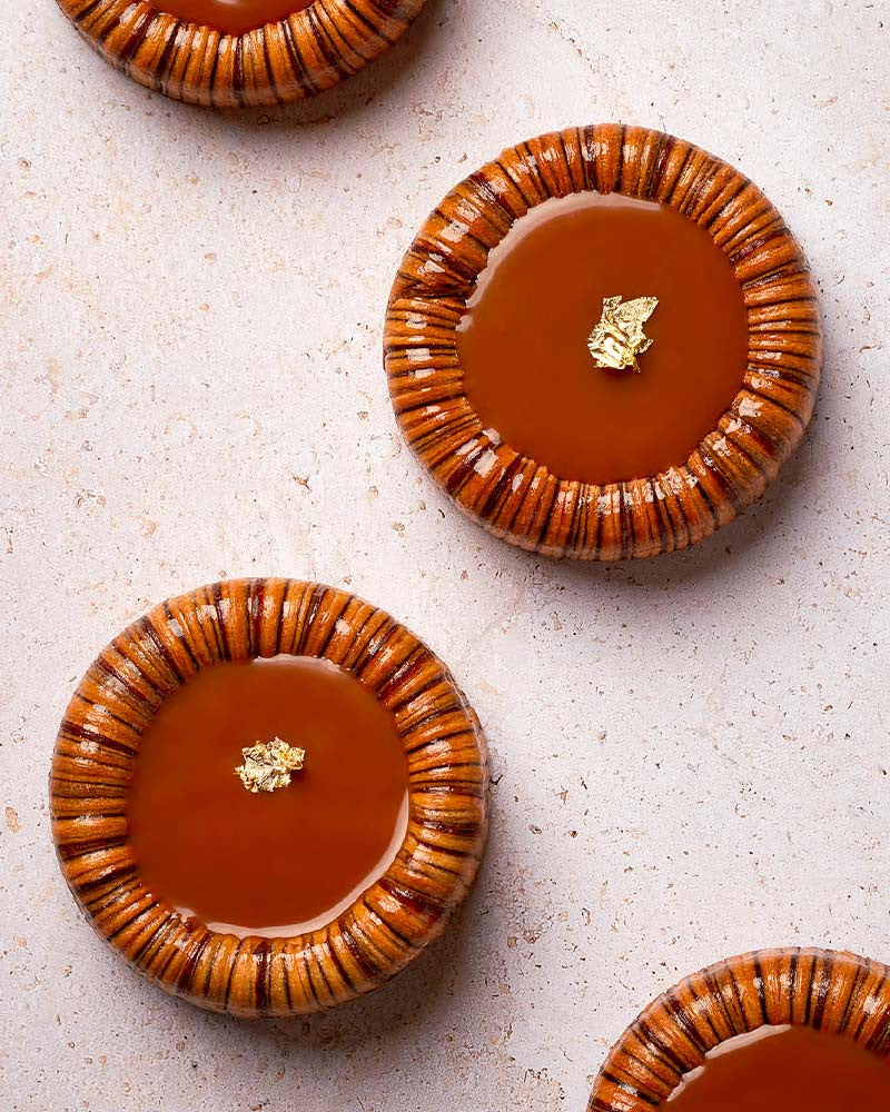 Caramel desserts with pecan crust on a light surface
