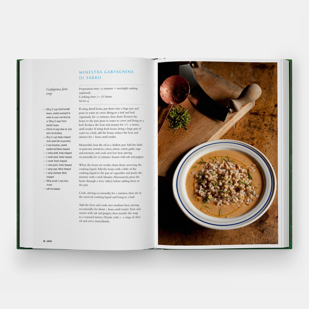 Open book showing a recipe with a bowl of soup on a wooden table